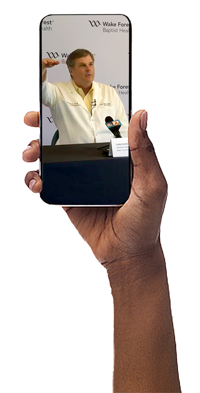 Hand holds up mobile phone with photo of Dr. Christopher Ohl