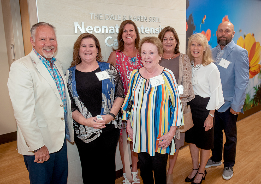 Karen Sisel stands with a group of family and friends at the opening of the Dale and Karen Sisel NICU at Wake Forest Baptist
